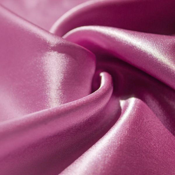 Close-up of pink soft silk fabric with a smooth surface and luxurious texture, highlighting the remarkable strength and enduring beauty of silk bedding.